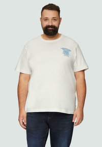 Witte katoenen t-shirt met korte mouwen, ronde halslijn en blauwe bedrukte tekst. Gecombineerd met donkere denim jeans.