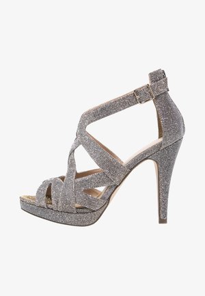 Srebrne brokatowe sandały na obcasie z otwartym palcem, ozdobione skrzyżowanymi paskami, klamrą przy kostce i podeszwą na platformie zapewniającą dodatkową wysokość. Teksturowane wykończenie.
