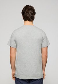 Camiseta de algodón gris con mangas cortas y cuello redondo, con una textura suave y un ajuste clásico, vista desde la espalda.