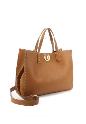 Bolso de cuero color coñac con doble asa superior, cierre dorado en forma de herradura, costuras blancas a lo largo de los bordes y correa de hombro desmontable sobre fondo blanco.