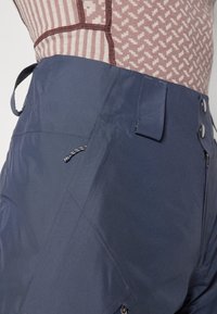 Ναυτικό μπλε ελαφριά παντελόνια εξωτερικού χώρου με λεία υφή, διαθέτουν τσέπη με φερμουάρ στο πλάι, ρυθμιζόμενη μέση και κλείσιμο με κουμπί.