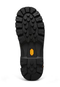 Sort gummi sål med dybe slidbaner til greb, med cirkulære og vinklede mønstre. Gul Vibram-logo indlejret i midten.