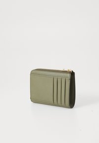 Green leather cardholder with six card slots and a zipper closure. Smooth texture with stitched edges, featuring gold-tone hardware accents.