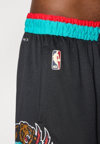 Schwarze Sportshorts aus strukturiertem Stoff mit einem türkisfarbenen und roten Bund, einem Bärenlogo und einem NBA-Patch an der Seite.