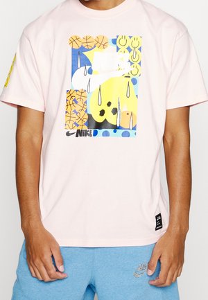Roze katoenen T-shirt met een kleurrafisch ontwerp met basketballen, abstracte vormen en het Nike-logo. Korte mouwen, relaxte pasvorm.