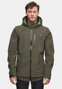 Ciemnooliwkowa kurtka softshell z kapturem, zapinana na zamek błyskawiczny z przodu oraz kieszenią na piersi. Posiada kontrastowe, jaskrawozielone wnętrze.