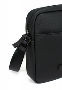 Borsa rettangolare nera realizzata in materiale testurizzato, dotata di chiusura con zip, tracolla regolabile e una piccola tasca frontale.