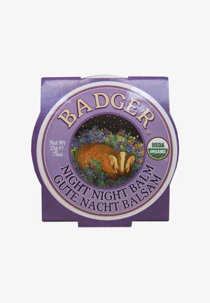 Balsamo Notte Badger, contenitore rotondo viola, presenta un'illustrazione di un tasso circondata da fiori, etichettato come USDA Organic. 21g.