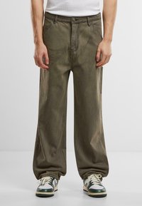 Wijde olijfgroene broek gemaakt van een gestructureerde stof, met voork nopjes, een metalen knoopsluiting en subtiele vervagingdetails.