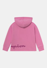 Felpa con cappuccio rosa realizzata in morbido tessuto, caratterizzata da una grande grafica in testo "champion" di colore rosa scuro sul retro, con polsini a coste.