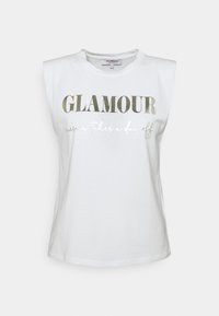 Camiseta sin mangas de algodón blanca con cuello redondo y hombreras. Presenta un texto metálico dorado: "GLAMOUR nunca se toma un día libre." Textura suave.