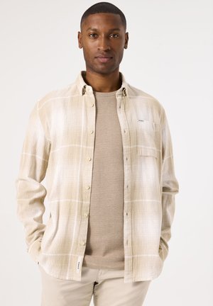 Langdurig mouw shirt in beige met een textuur gebreide onderlaag. heeft knoopsluiting, zak en een ontspannen pasvorm.