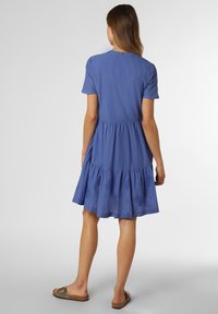 Blaues Kurzarmkleid mit einem gestuften Rock und subtilen Blumenmuster. Glatter Stoff mit lockerer Passform, versehen mit einem Knopfverschluss im Rücken.