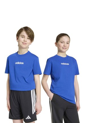 Deux enfants présentent des tee-shirts Adidas bleus et des vêtements de sport noirs sur un fond blanc.
