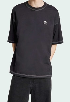 Schwarzes Baumwoll-T-Shirt mit lockerem Schnitt, rundem Ausschnitt, kurzen Ärmeln, kontrastierenden weißen Nähten und kleinem weißen Adidas-Logo auf der Brust.