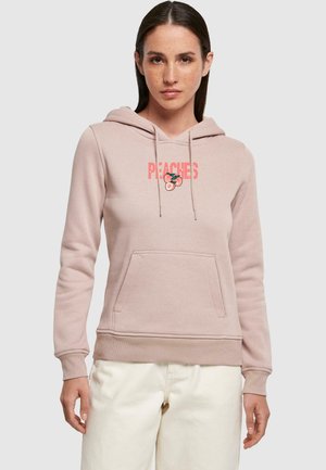 Ljusrosa hoodie med framficka, dragsko för huvan och en grafik med texten "PEACHES" samt körsbärsdesign. Mjuk tyg och ribbade ärmslut.