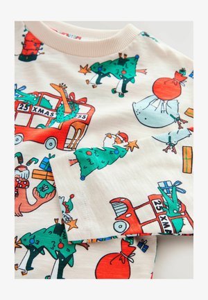 Bavlněná košile s barevnými vánočními potisky, včetně ozdobených stromů, dárků a červeného autobusu, na krémovém pozadí a s vroubkovaným límečkem.