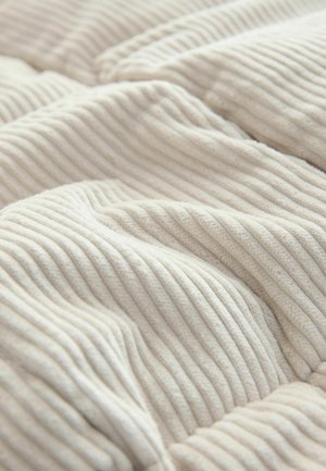 Puha, bordázott krémszínű anyag, kellemes tapintású, finom redőkkel és enyhe fényű felülettel, ami meghitt megjelenést kölcsönöz.