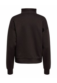 Rjavi pulover z visoko ovratnico, spuščeni šivi na ramenih in rebrastimi manšetami. Mehka struktura tkanine in sproščen kroj.