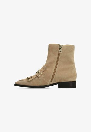 Beige suede ankle boot with a pointed toe, decorative hardware, and side zipper. Features a low, stacked heel and smooth texture.