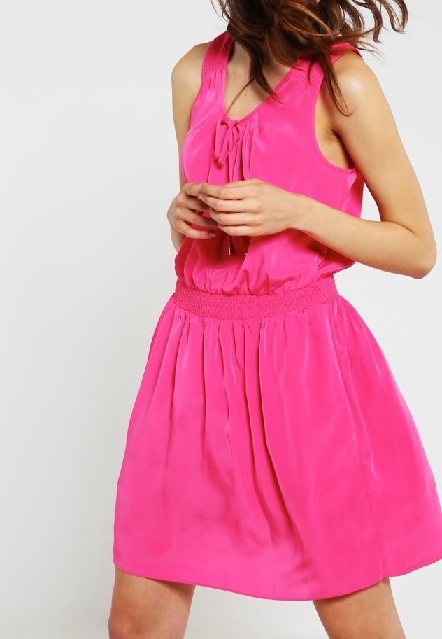 Ärmlös rosa klänning i slät tyg, med en rynkad elastisk midja och rosett-detalj vid halslinningen.