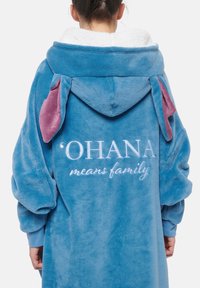 Accappatoio blu in pile con fodera interna viola e orecchie. Presenta la scritta ricamata "‘OHANA significa famiglia" sulla schiena. Texture morbida.
