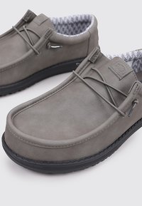 Grijze suède instappers met een gestructureerde voering, zwarte rubberen zool en een minimalistisch vetersysteem. Bevat subtiele branding op de zijkant.