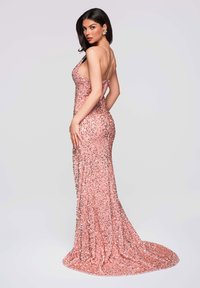 Vestido de lentejuelas en oro rosa con silueta ajustada, tirantes finos y falda larga que se extiende en una elegante cola.