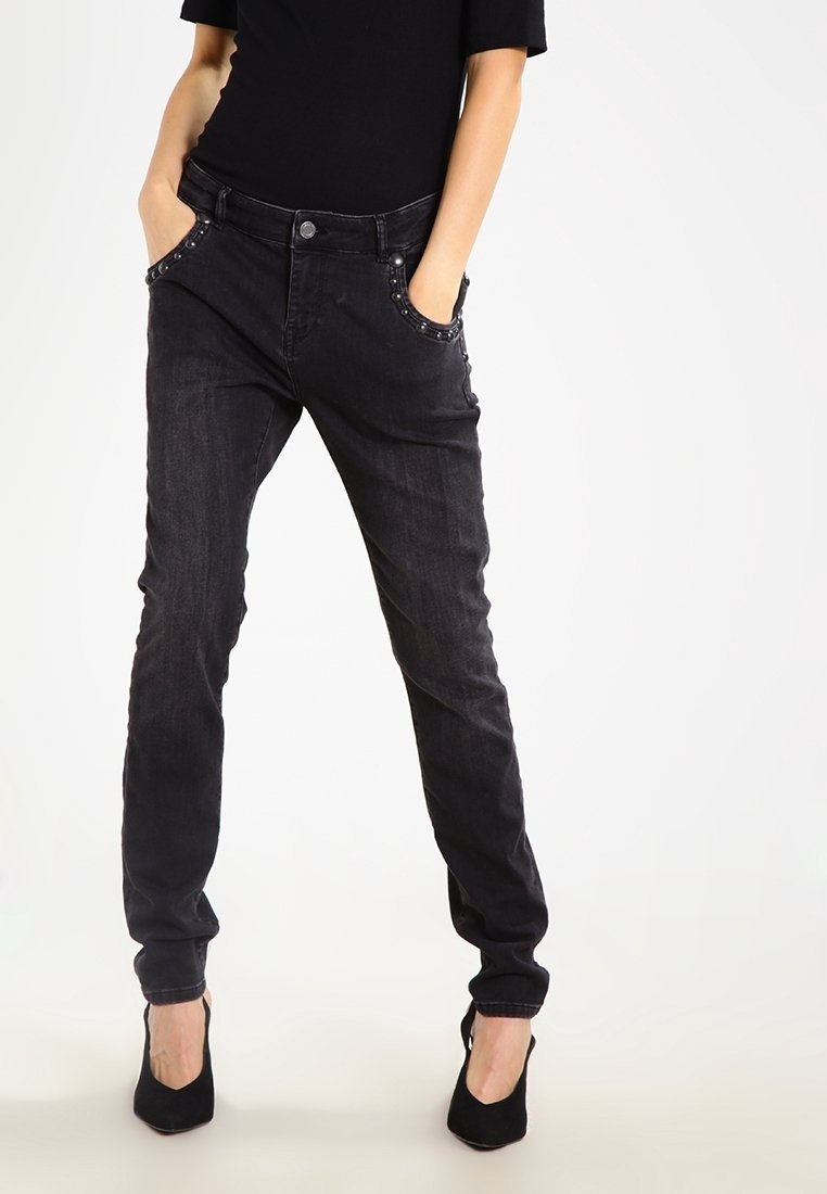 Černé džíny z denimu s úzkým střihem, obsahující dekorativní cvočky podél předních kapes, pět kapsový design a světlé vyblednutí.