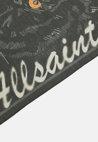 Tessuto nero con una finitura testa di moro, caratterizzato da un grande design di un gatto e testo bianco che recita "Allsaints." I bordi sono cuciti in modo ordinato.