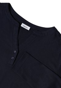 Marineblaue Baumwollbluse mit langen Ärmeln, V-Ausschnitt, zwei Knöpfen an der Knopfleiste und einer einzigen Brusttasche. Mit einer glatten Textur.