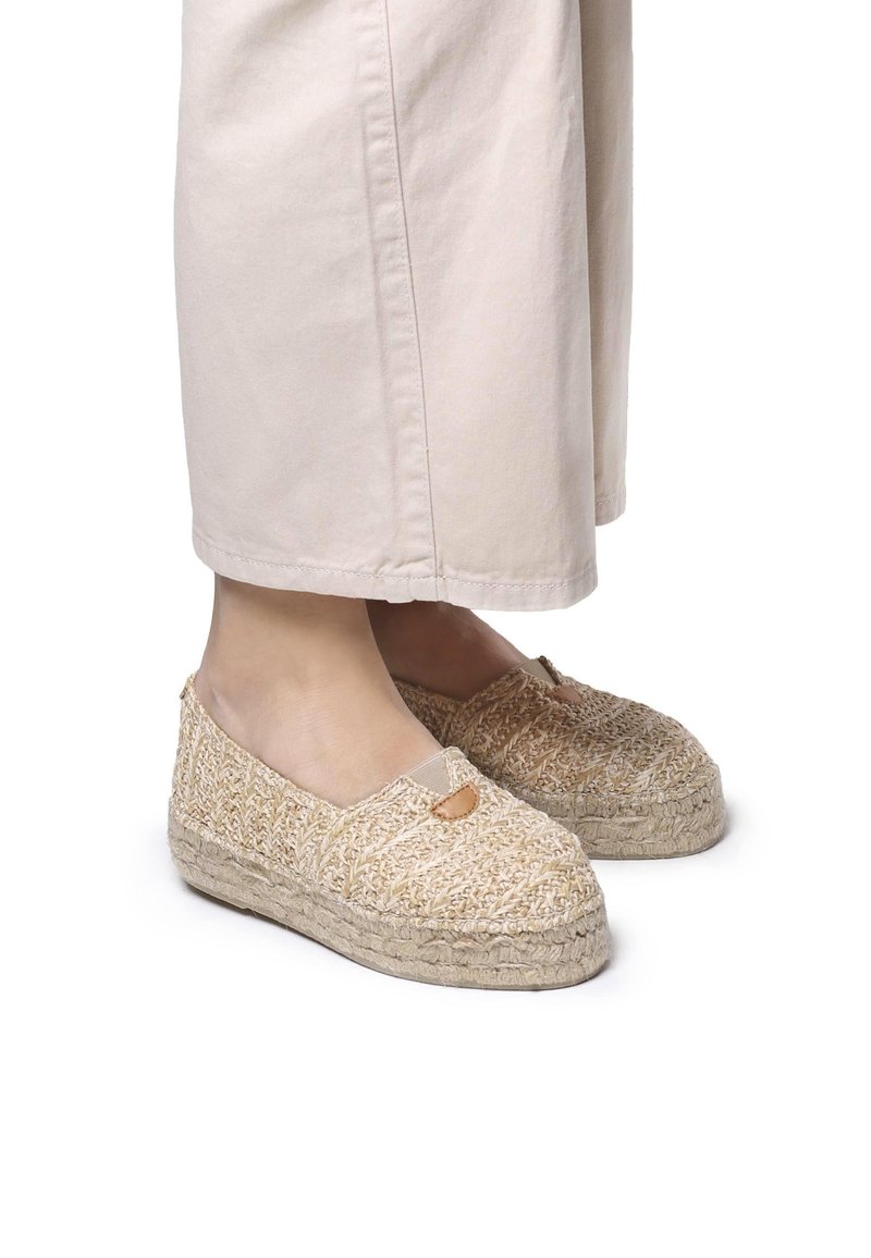 Espadrillas beige intrecciate con una finitura testurizzata, dotate di punta arrotondata e un piccolo dettaglio a taglio, montate su una suola in corda naturale.