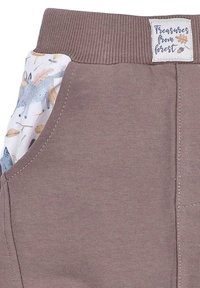 Brune bomuldsbukser med ribbet talje og sidelomme, udlagt med et skov-tema trykt stof, der inkluderer grå dyr og blade.