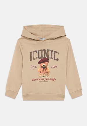 Bežna otroška kapuca s kapuco, grafika medvedka, ki nosi bareto, in besedilom "IKONIČNO," "Ne skrbite, bodite medvedek," in ustanovljeno 1986.