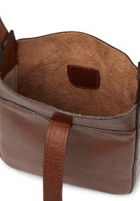 Brun läderväska med en mjukt strukturerad insida. Har en enkel design, platt rem och en liten innerficka av strukturerat material.