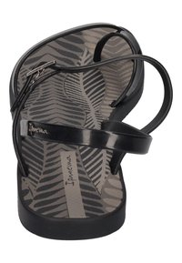 Black flip-flop with a textured gray leaf-patterned footbed and thin, glossy straps. Features a logo on the strap and a flat sole.