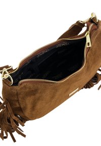 Hnědá semišová kabelka přes rameno se zlatým zipem, zdobená třásněmi. Interiér je podšívkován černou tkaninou s logem značky.
