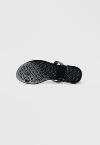 Black sandal sole with a textured, diamond-patterned surface. Features smooth straps and a flat design for comfort and stability.