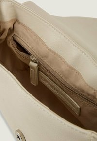 Interno della borsa beige con un rivestimento esterno in pelle texturizzata, dotato di un compartimento principale e una tasca con zip foderata in un tessuto chiaro.
