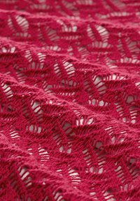 Tissu en dentelle de couleur rose foncé avec un motif floral répétitif. La texture est ouverte et aérienne, présentant des détails tricotés complexes.