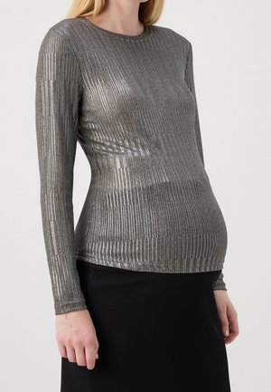 Metallinhohtoinen hopeanvärinen pitkähihaisen pusero, jossa on ribbineulos, pyöreä pääntie ja kapea istuvuus, yhdistetty mustaan ribbineulottuun hameeseen.