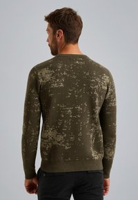 Olijfgroene trui met een gestructureerd patroon, ronde halslijn en lange mouwen. Ribgebreide manchetten en zoomdetails verbeteren het ontwerp.