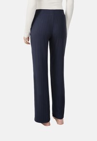 Pantaloni larghi a coste color navy con una cintura morbida, caratterizzati da una superficie testurizzata e una vestibilità ampia, che arrivano alla caviglia.