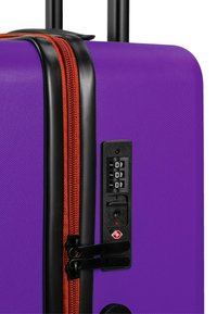 Paarse hard-shell koffer met een oranje rits, zwarte hardware, een ingebouwd combinatieslot en een gestructureerd oppervlak voor grip.