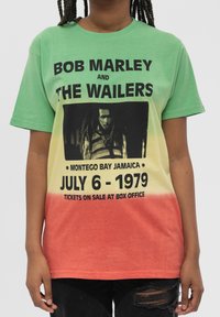 Green to red gradient cotton T-shirt featuring a black graphic of Bob Marley, with bold text detailing a concert date and location.