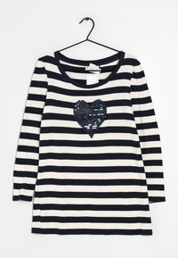 Gestreiftes Langarmhemd in Marine und Creme mit einem Pailletten-Herzdruck. Hergestellt aus weichem Stoff, mit einem runden Ausschnitt und seitlichen Schlitzen.