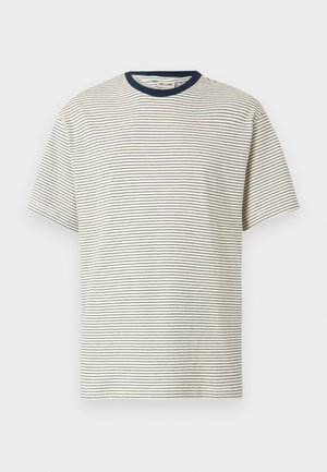 Valge lühikeste varrukatega t-särk, millel on õhukesed horisontaalsed mustad triibud ning tume meresinine ümmargune kaelus.