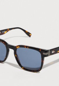 Tortoise shell square sunglasses with dark blue lenses and silver accents on a white background.