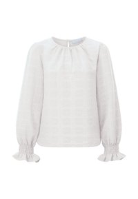 Blouse blanche texturée à manches longues, avec un col froncé et des poignets à volants smockés. Présente un motif floral embossé sur tout le tissu.
