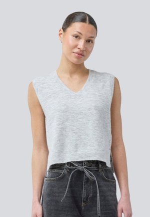 Lys grå, ermeløs strikkevest med V-hals. Myk tekstur, litt kortere passform, kombinert med mørk grå høyt liv jeans og et knyttet belte.